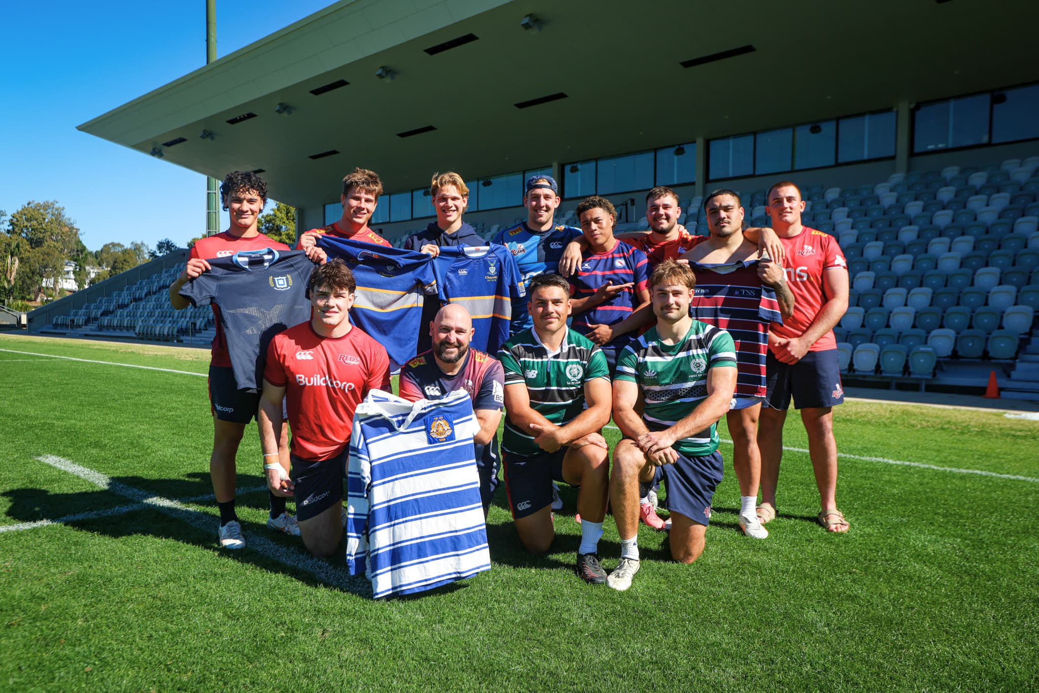 Reds showing their school colours...(from top left) Harper Enasio (Brisbane Grammar), Nick Bloomfield (Churchie), Frankie Goldsbrough (Churchie), Charlie Brosnan (Churchie), Josh Takai (BSHS), Massimo De Lutiis (TSS), George Blake (TSS) and Kingsley Uys (TSS). At front: Levi Slater (Nudgee), assistant coach Zane Hilton (Nudgee), Zac Hough (BBC) and Xavier Rubens (BBC). 