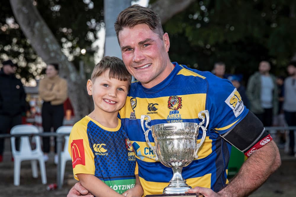 Ben Mowen sharing the Battle of the Bridge trophy win over GPS with son Jackson, 6. Photo: Brendan Hertel, QRU