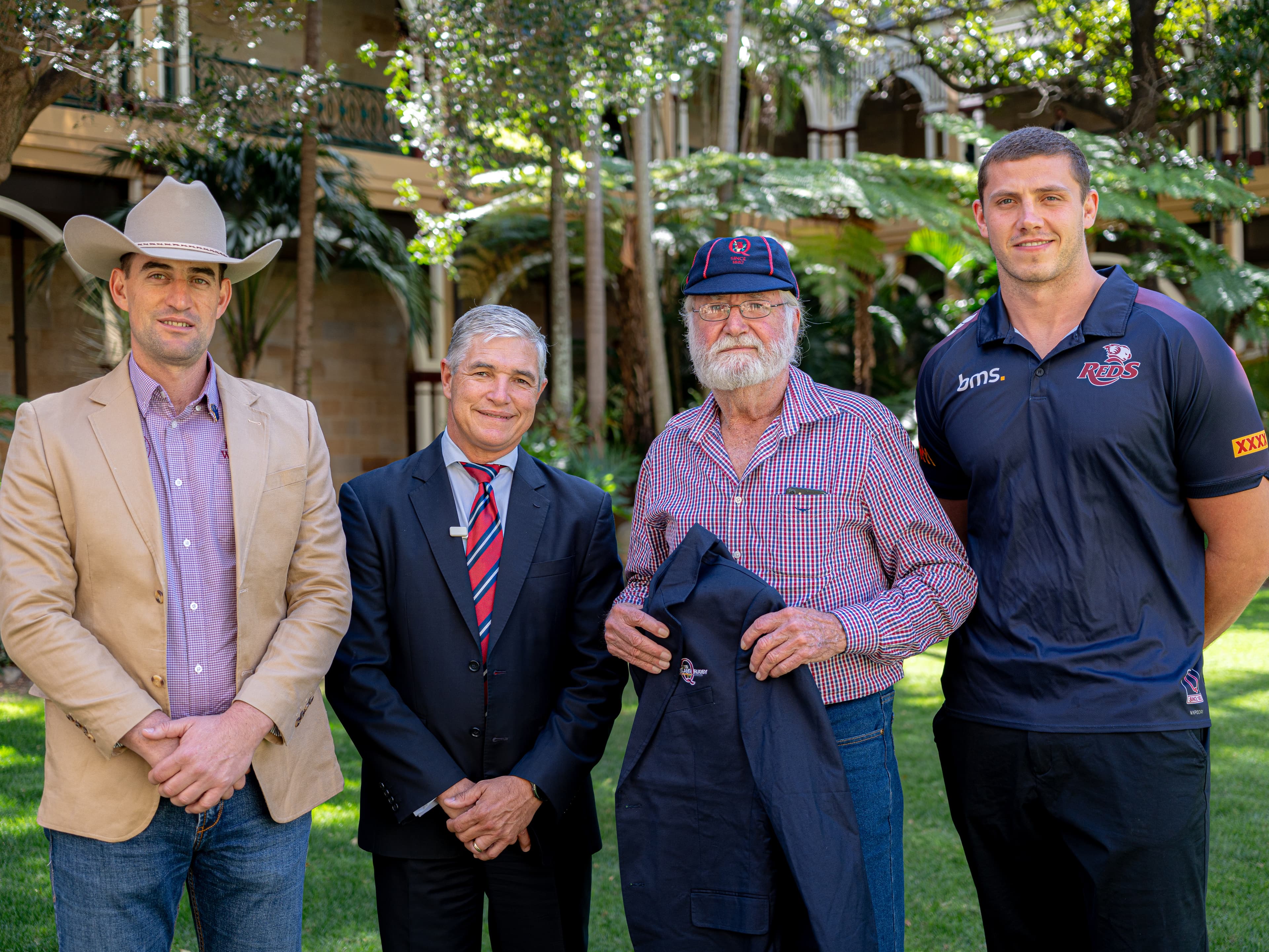 Former Queensland player Peter Fleming (third from left) being presented with a new Reds blazer and honour cap by Ringers Western co-founder Matteo Salerno, Member for Traeger Robbie Katter and Reds lock Josh Canham at Parliament House in Brisbane.