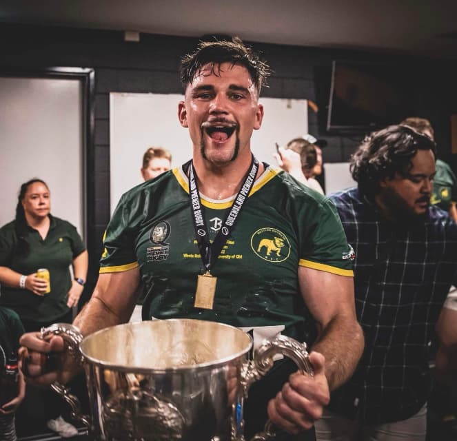 Harry Higgins celebrating Wests' 2022 grand final win with the Hospital Cup. Photo: Brendan Hertel, QRU