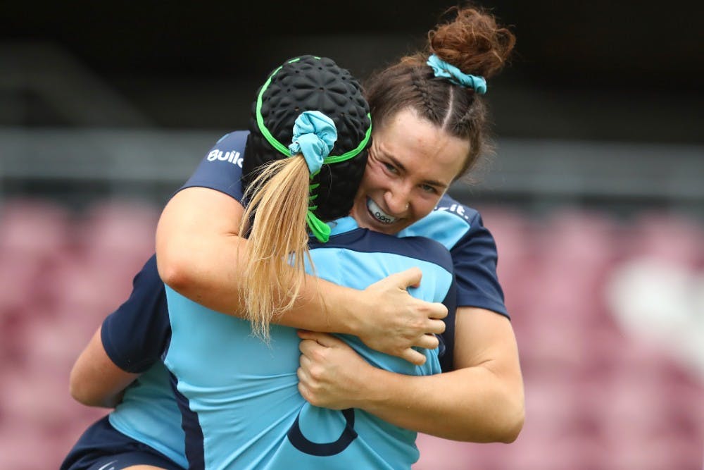 Waratahs winger Maya Stewart embraces a teammate after scoring a try to put NSW ahead against the Reds. Photo: Getty Images