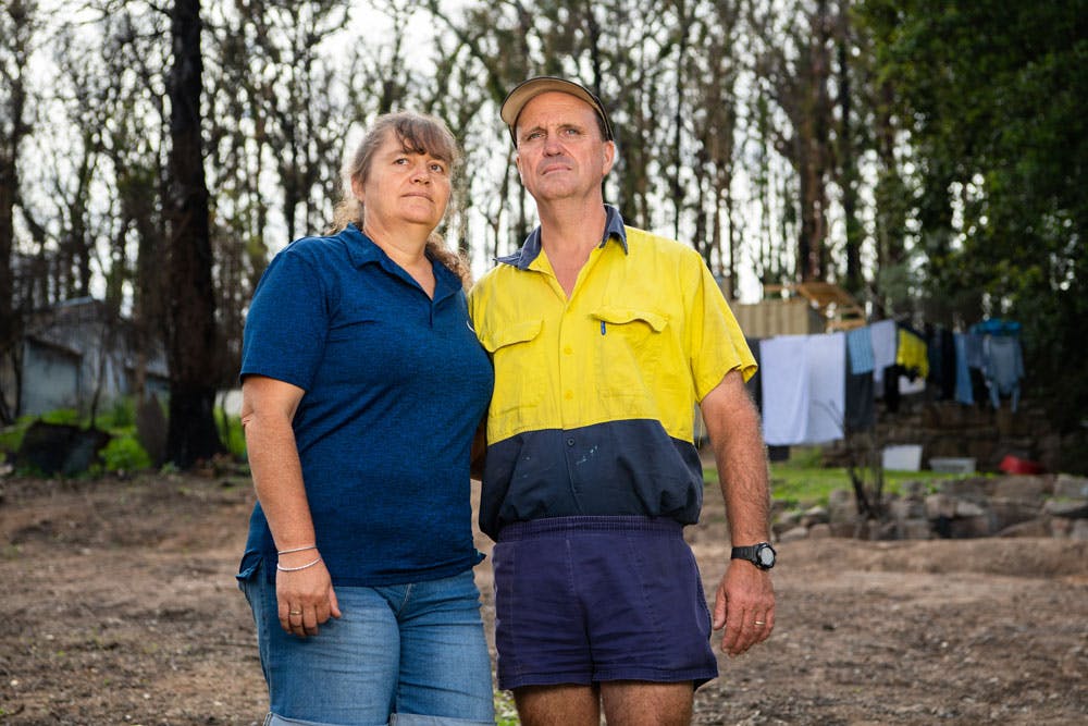 Peter and Jenny McGann stand where their home used to be in Mogo. Photo: Rugby AU Media/Stuart Walmsley